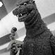 Mondo's figure of a toothy Godzilla, clutching an airplane, as he looked in 1954.